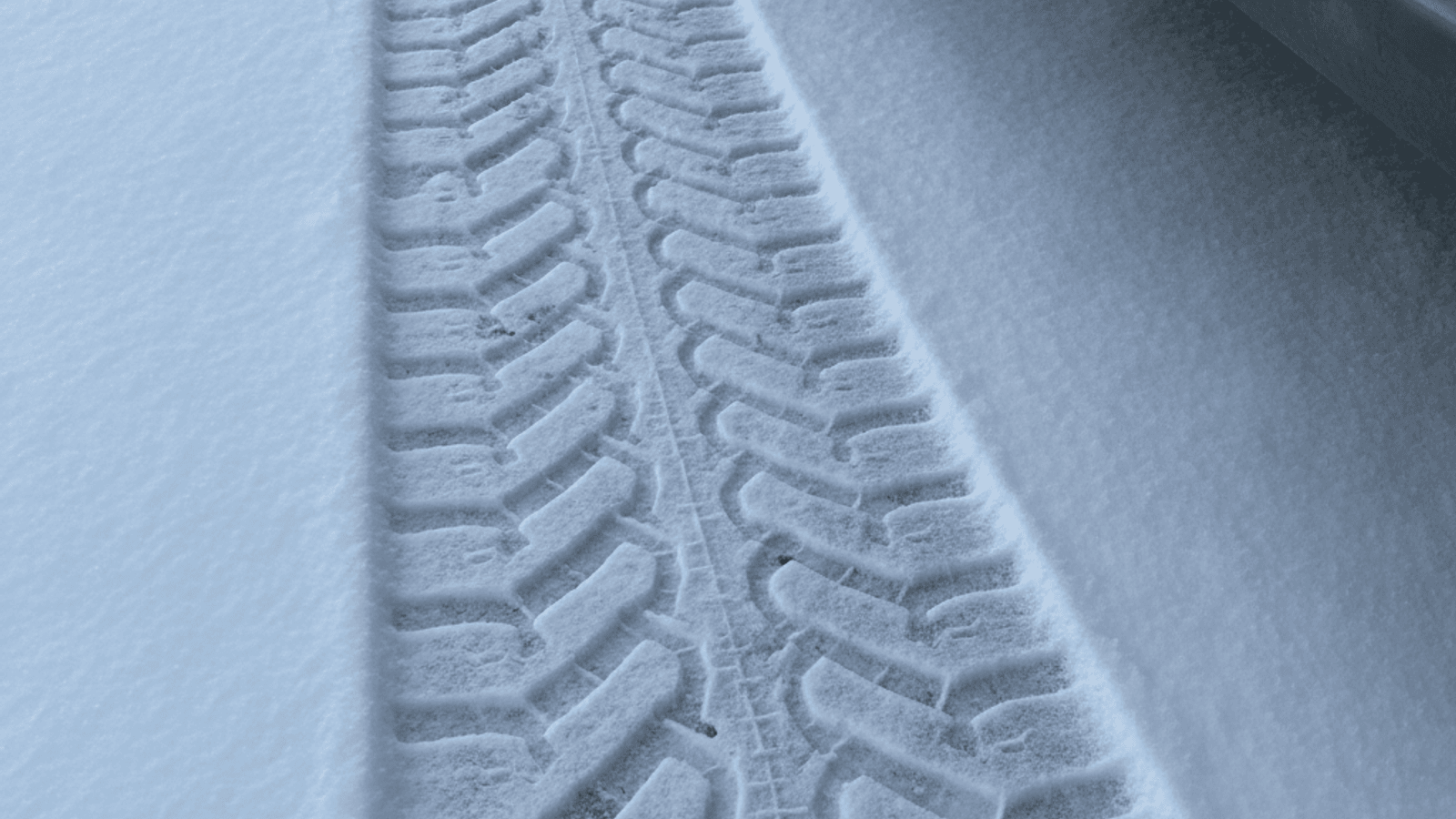Close-up of a tire tread on snow-covered pavement
